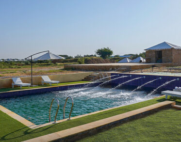 Dive into a cool, crystal-clear pool, offering a refreshing escape amidst the sweeping, sun-kissed desert views