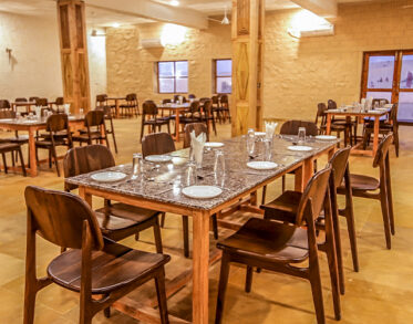 Step into our beautifully curated dining hall, where warm lights and fine wood create an elegant ambience